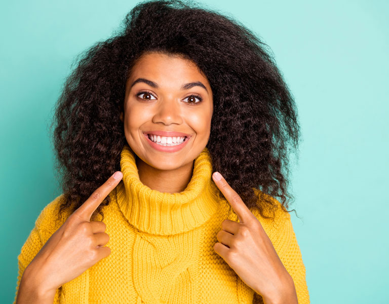 African-American woman pointing at her teeth in Stafford, VA