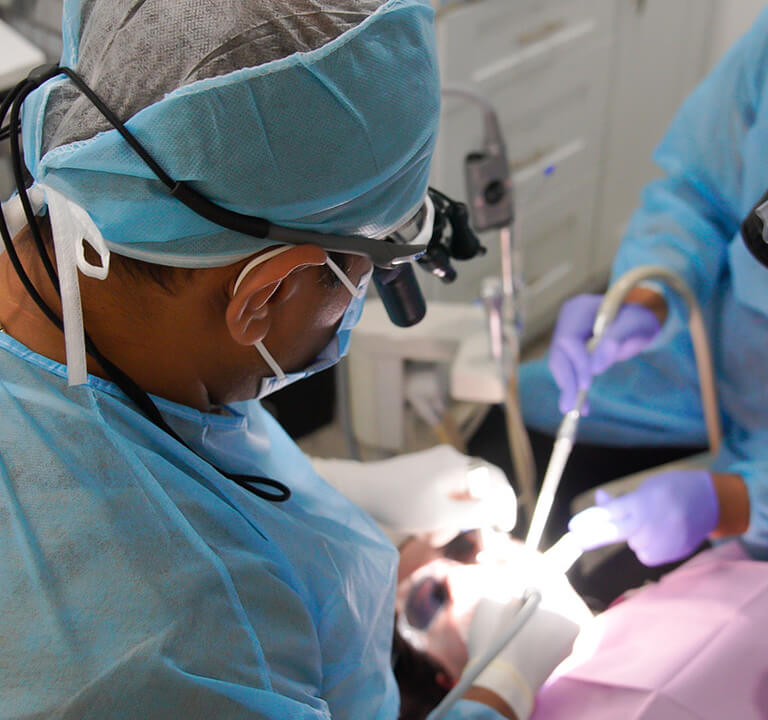 A dentist performing a surgery at Karande Biological Dentistry